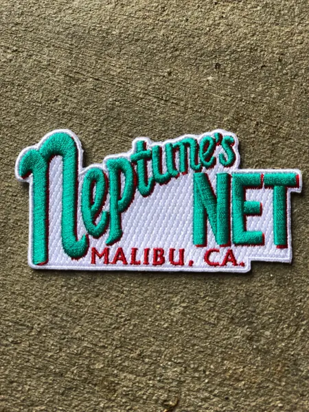 A patch that says neptune 's net in green and white.