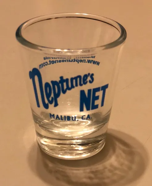 A shot glass with the name neptune 's net on it.